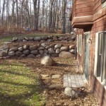 back yard after boulder walls and paver pad