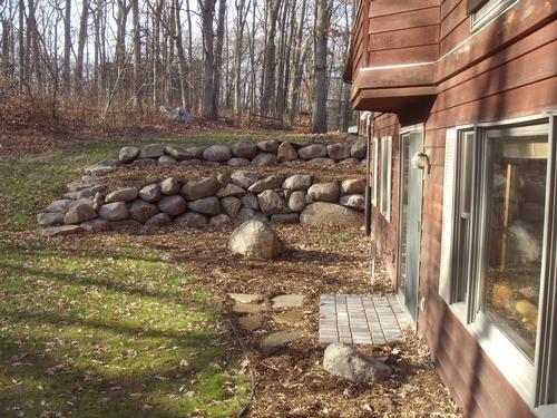 Two tiered boulder wall project complete by Wolf Landscaping