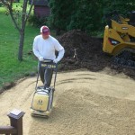 packing the sand before adding pavers - Wolf Landscaping